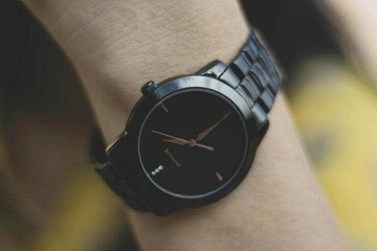 Detailed close-up of a sleek black analog wristwatch focusing on its design and sophistication.