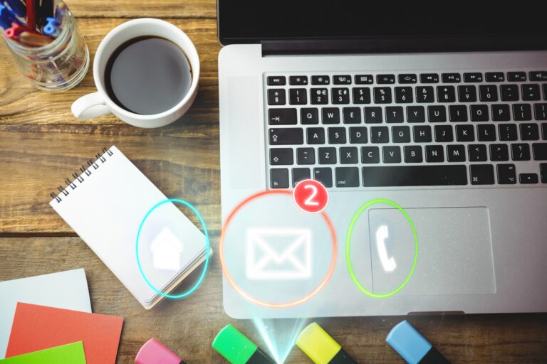 A laptop on a desk showing a glowing email marketing icon, highlighting direct customer communication
